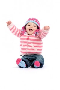A 8 month old baby girl sitting on the floor